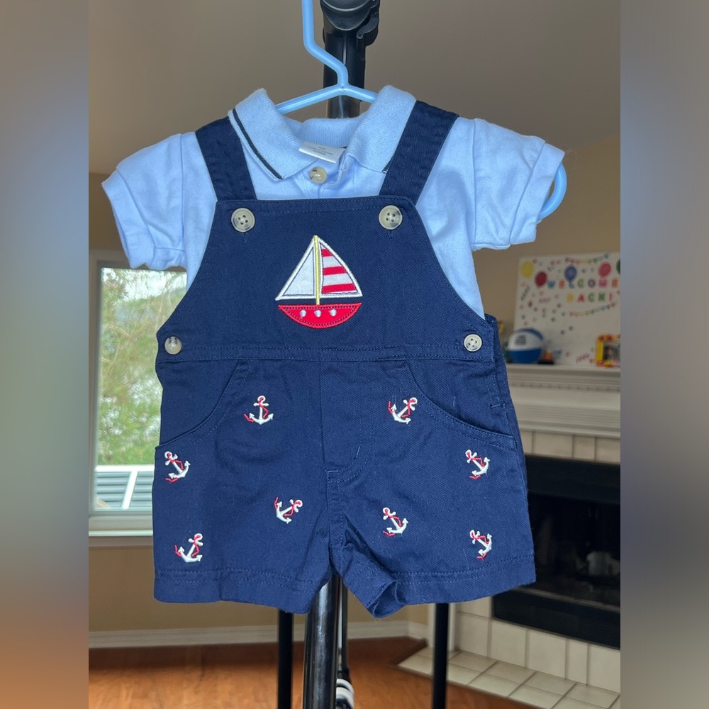 Boys light blue collared shirt and nautical-themed overalls.